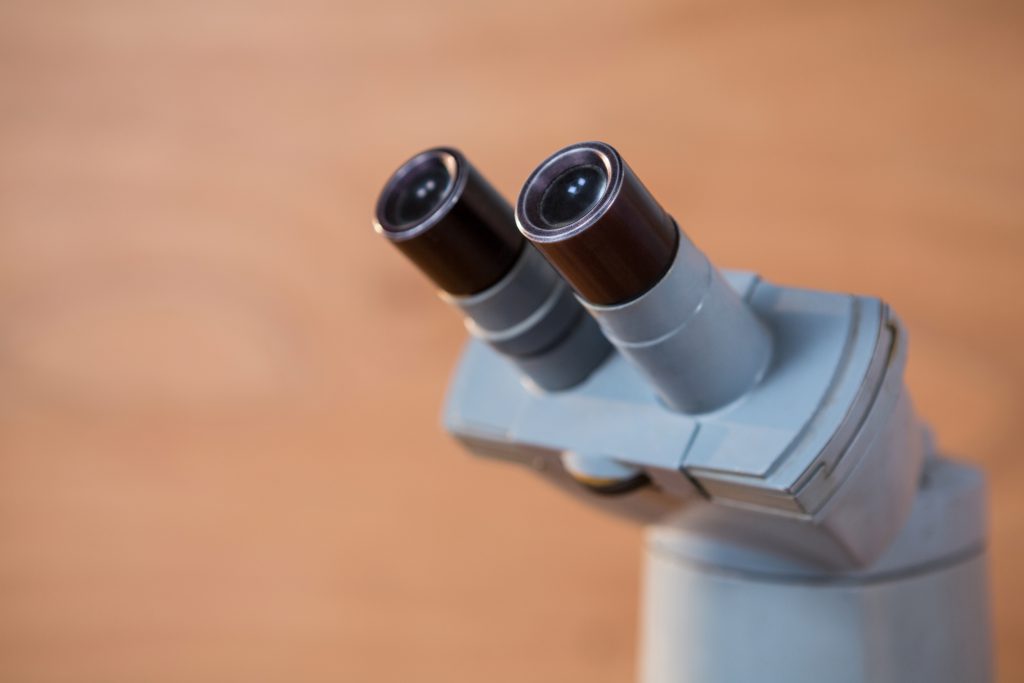 Technician maintaining a metallurgical microscope for optimal performance.
